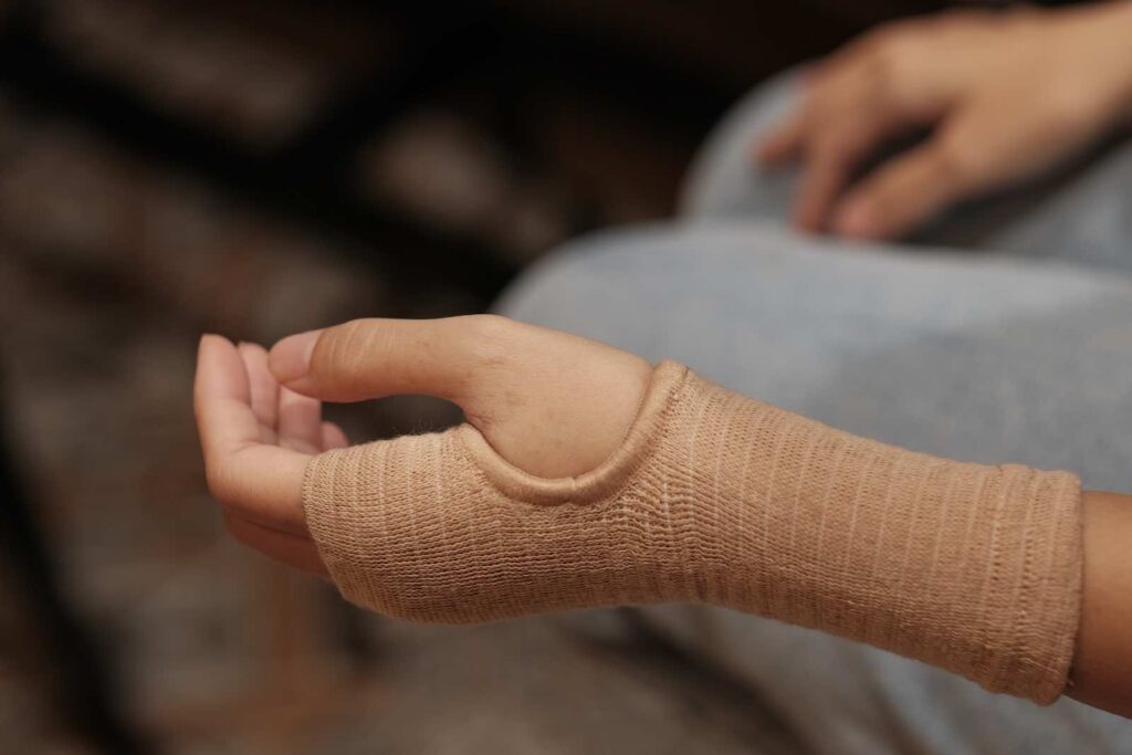 Patient lächelt bei der erfolgreichen Durchführung einer Übung in der Handtherapie bei Leonie Kruse. Der Erfolg der Ergotherapie ist sichtbar.