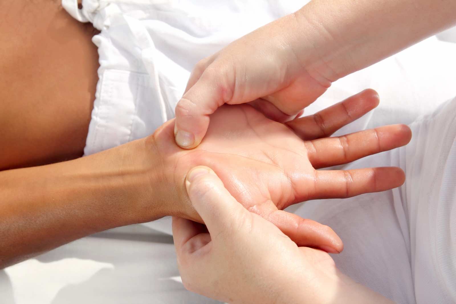 Ergotherapeutin Leonie Kruse bei der Behandlung eines Patienten; Fokus auf die Narbenmobilisation als Teil der spezialisierten Handtherapie nach einer Hand-OP.